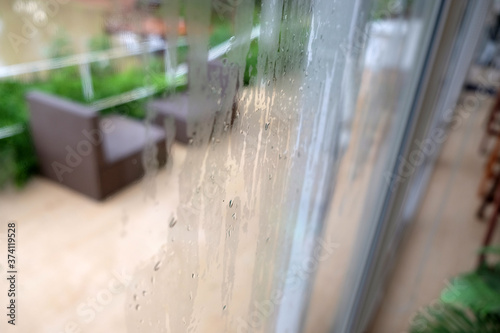 Rain drops on the glass window with cafe Background