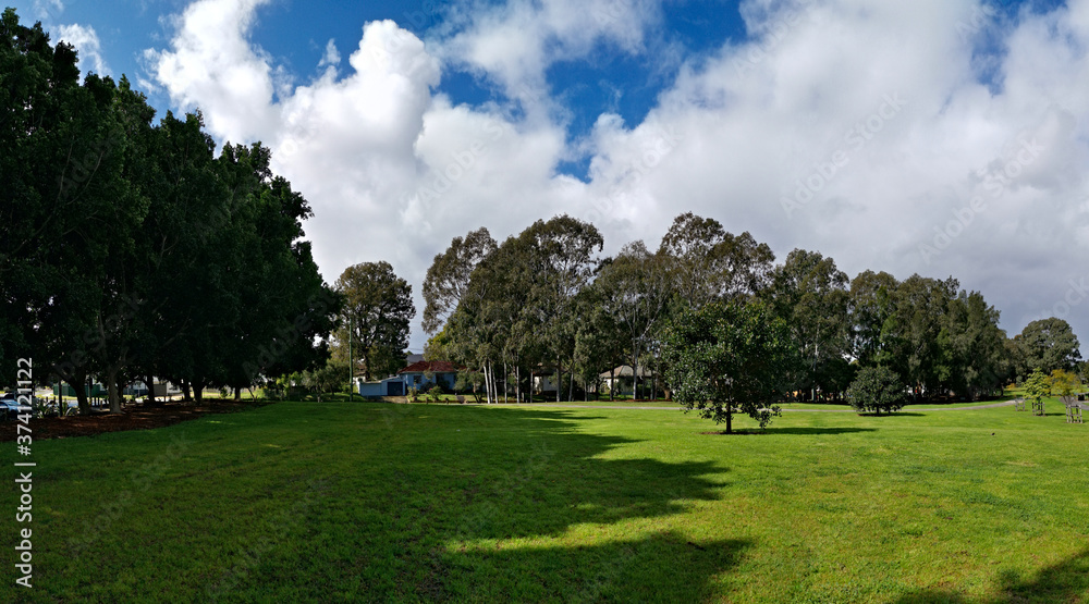 Beautiful view of a park with green grass, tall trees and paved trail for walking and cycling, Reid Park, Parramatta Cycleway, Rydalmere, Sydney, New South Wales, Australia
