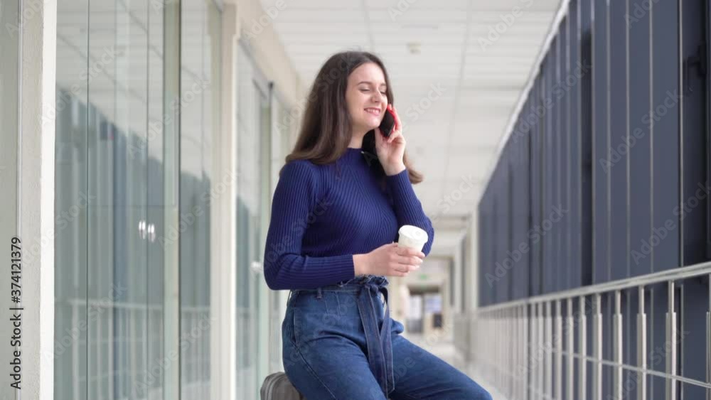 Travelling girl with luggage and coffee while waiting for the plane talking on the phone. Travel after quarantine Travelling girl with luggage and coffee while waiting for the plane talking on the phone. Travel after quarantine