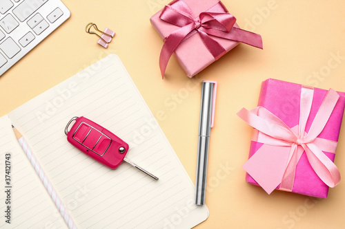 Gift boxes with car key and stationery on table photo