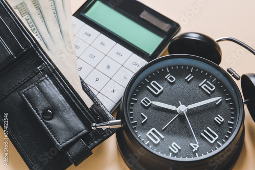 Alarm clock with calculator and money on table