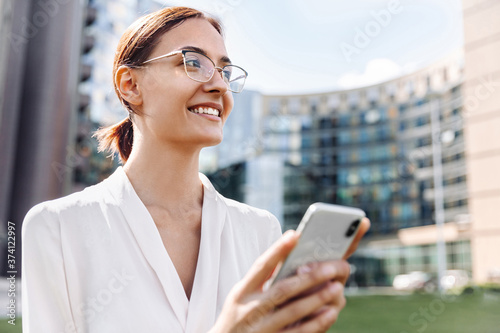 Close-up portrait of smiling business woman with mobile phone Free Download Close-up portrait of smiling business woman with mobile phone - GFXLoad