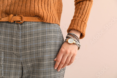 Woman with stylish wrist watch on color background, closeup