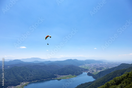 夏の木崎湖上空を滑空するパラグライダー 長野県大町市