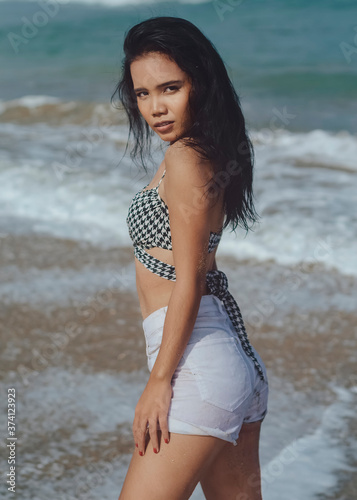 Balinese girl with brackets on her teeth on the beach on a bright sunny day