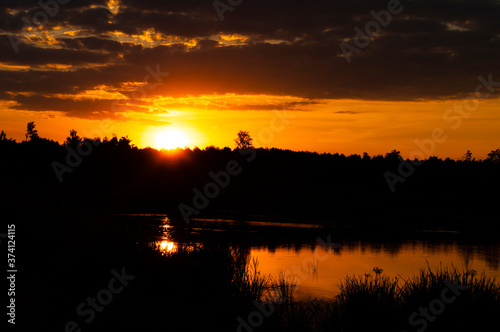 orange sunset over the river. sunset over the river. beautiful warm summer red sunset