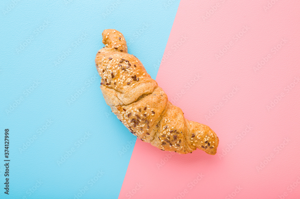 Fresh croissant sprinkled with grains on light blue pink table background. Two sides. Closeup. Top down view. Fresh croissant sprinkled with grains on light blue pink table background. Two sides. Closeup. Top down view.
