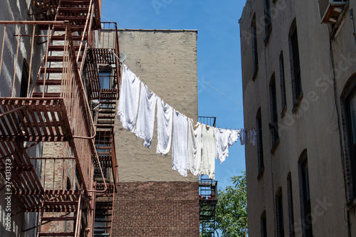 Canvas-taulu Urban Outdoor Clothes Line with White Clothes and Fire Escapes on New York City