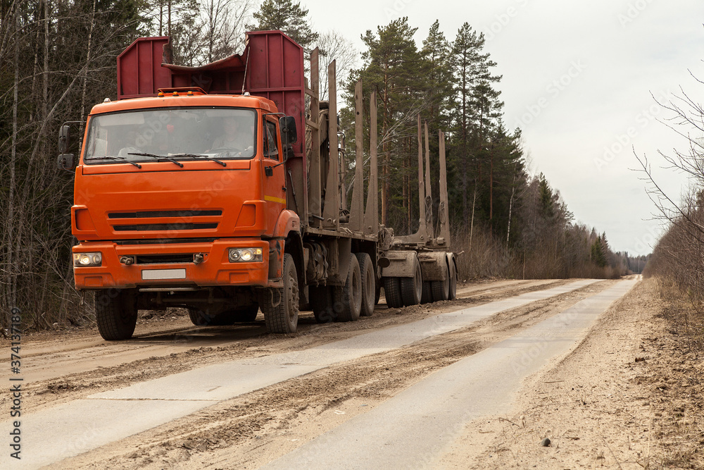 Orange empty Russian timber truck on a dirt road Orange empty Russian timber truck on a dirt road