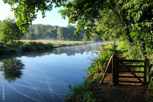 Early morning mist over the meadows on the River Wey in Godalming, Surrey, on a cold autumn morning. photo