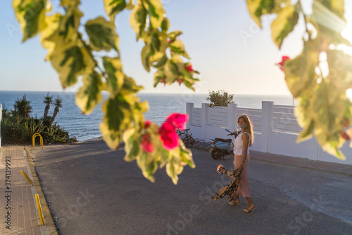 Chica joven llegando a la bajada de una playa de cadiz