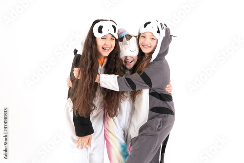 Cute teenage girls in kigurumi and sleep masks smiling and hug. World smile day. photo