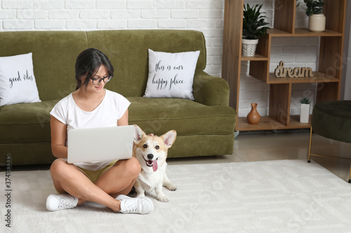 Remote work and work-life balance, young woman using laptop on living room fl...