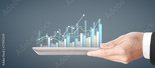  Plan graph growth and increase of chart positive indicators, tablet in hand
