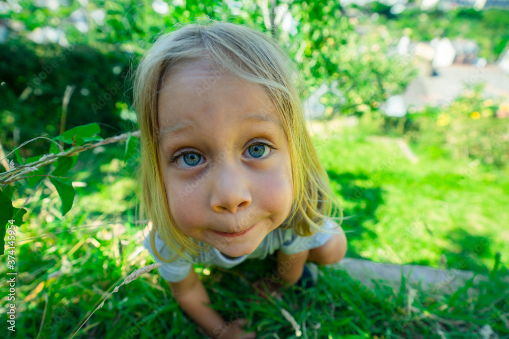 Little preschooler boy in garden pulling faces Little preschooler boy in garden pulling faces