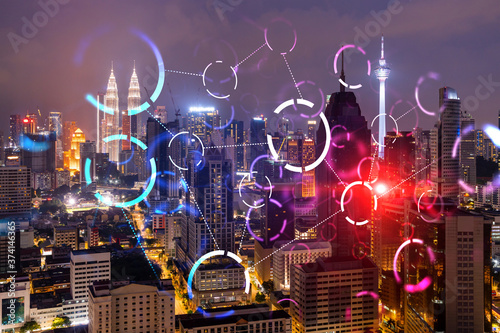 Abstract technology icons, night aerial panoramic cityscape of Kuala Lumpur, Malaysia, Asia. The concept of innovative approach to optimize international business process. Double exposure.
