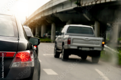 Rear light of car on asphalt road. The traffic is clear and there are bridges on the sides. © thongchainak