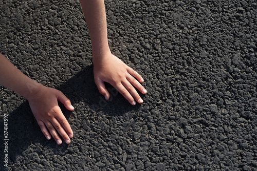 children's hands on black road I touch her, conceptual plot,