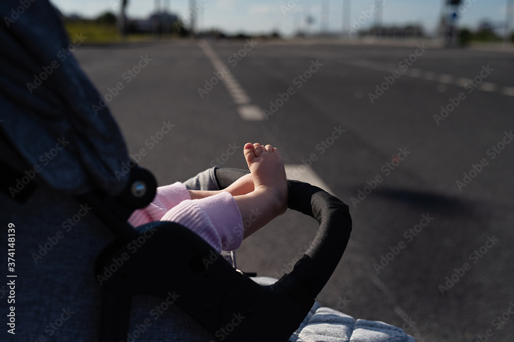 little baby feet sticking out of  stroller,  concept of child safety on  road