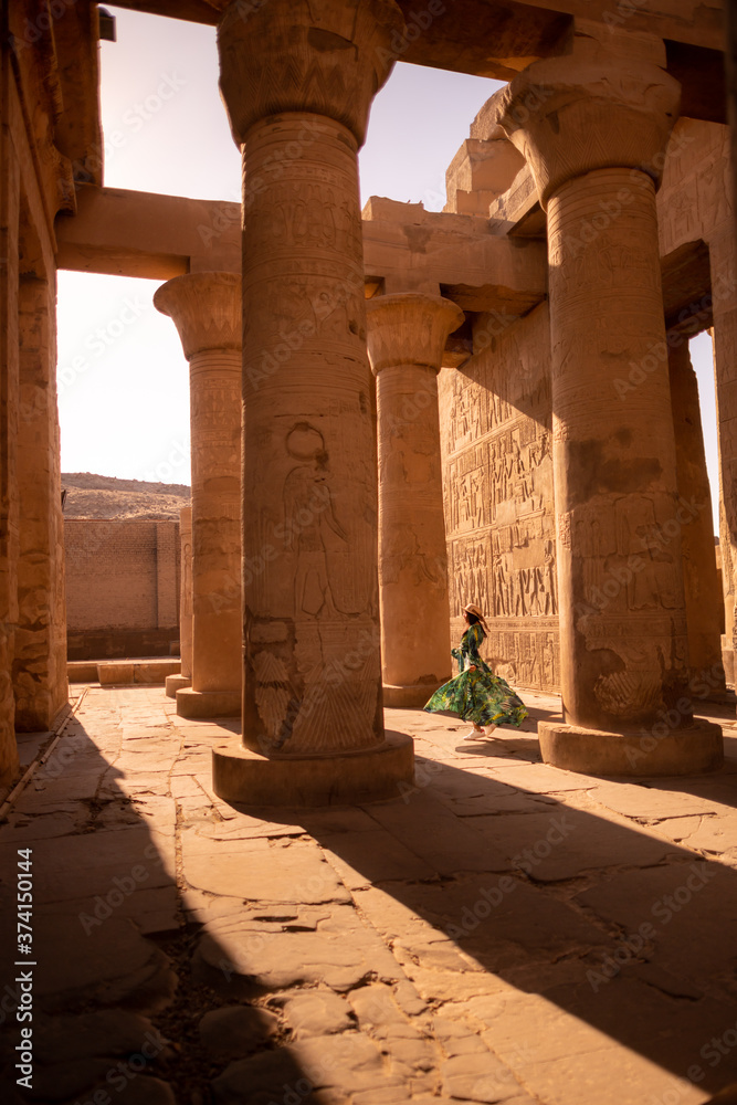 Women walking between large ancient pillars of Egypt, Appreciate the beauty of ancient things.