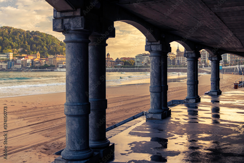 Fototapeta premium first lights of the day on the beach of la cocha in san sebastian, spain