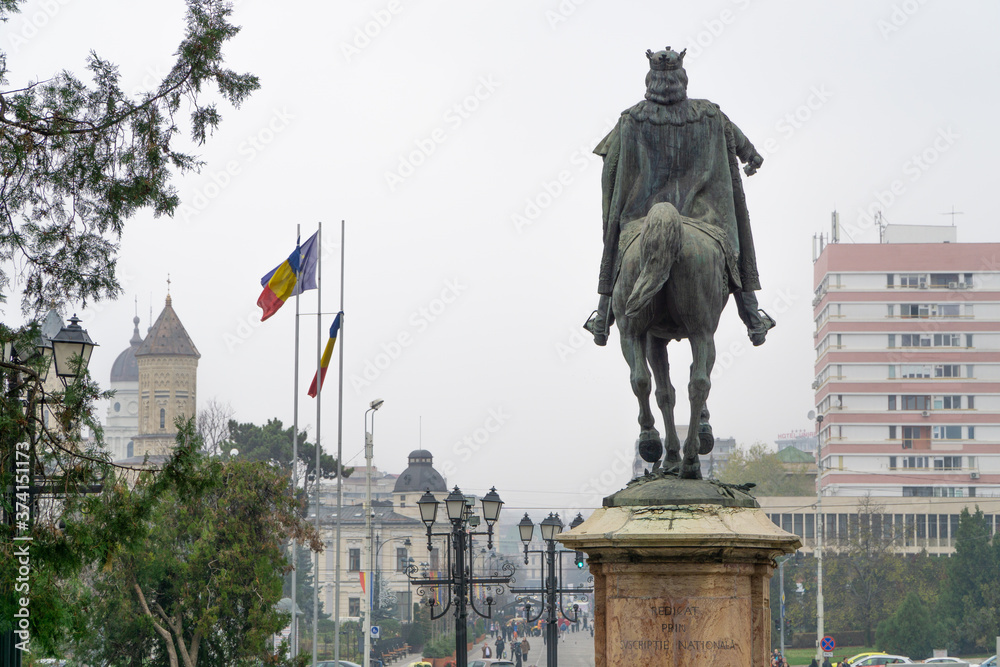 Fototapeta premium Stefan the Great statue with romanian flags fluttering in the background