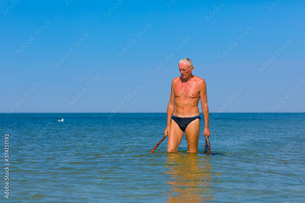 Man is hunting in the sea in shallow water.