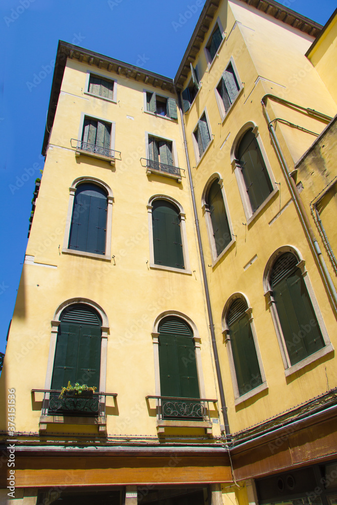a yellow building in Venice with small balconies