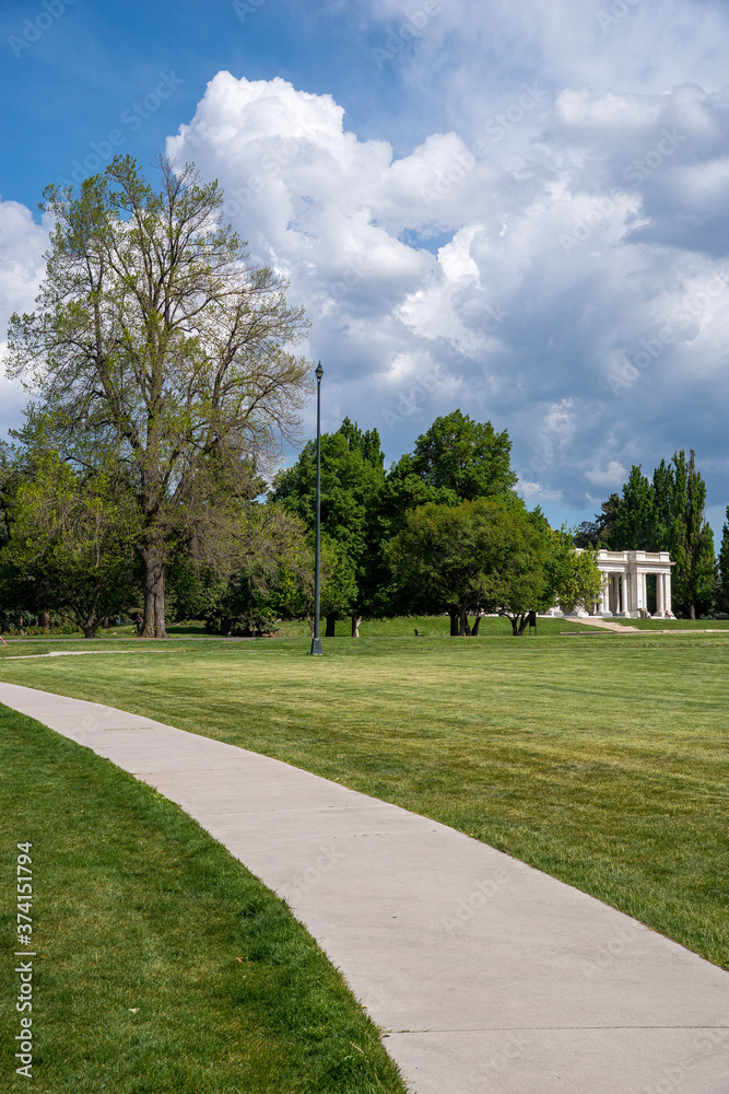 Peaceful scenery with roads over the lawn and trees, blue sky and clouds