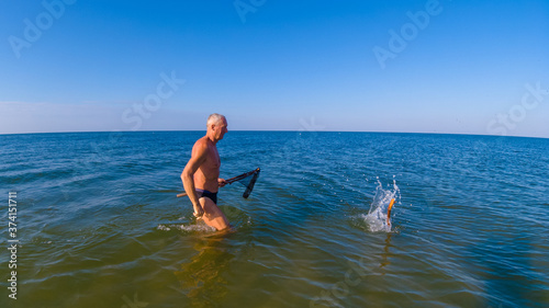 Man is hunting in the sea in shallow water.