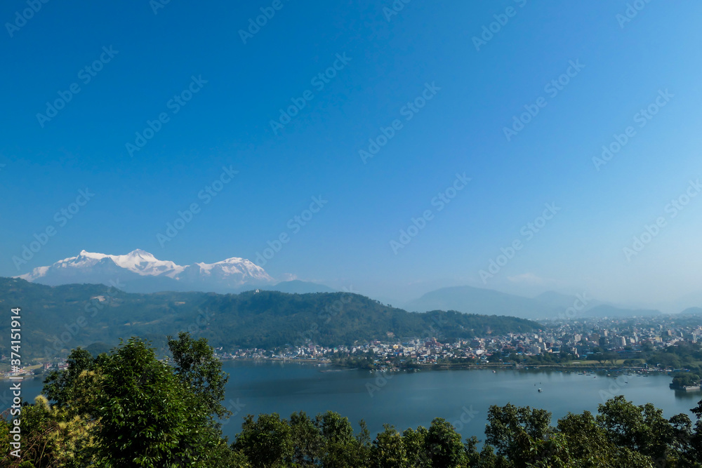 Panoramic view on Phewa Lake from World Peace Pagoda in Pokhara, Nepal. In the back there are high, snow capped Himalayan chains, with Mt Fishtail (Machhapuchhare) between them. Serenity and calmness Panoramic view on Phewa Lake from World Peace Pagoda in Pokhara, Nepal. In the back there are high, snow capped Himalayan chains, with Mt Fishtail (Machhapuchhare) between them. Serenity and calmness