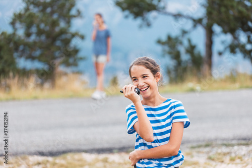 Two girls playing with walkie-talkies in the mountains