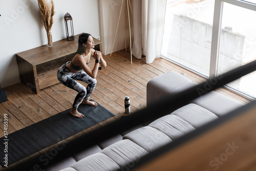 Image of beautiful asian girl doing yoga exercise while working out