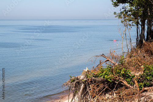 Karkle. Olado Kepure. Baltic sea coast. Forest by the sea. High Cliff. People are resting on the shore. A narrow beach at the foot of the cliff. People walk and sunbathe on the coast. Pine forest  photo