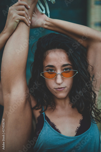 portrait of a young beautiful woman with sunglasses and a leg up 