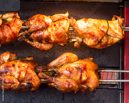 Принти на полотні Close up photo of roasted chickens on spits in a grill