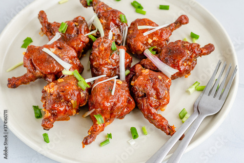 Photography Chicken Lollipop - Popular Indo-Chinese Chicken Appetizer on a White Plate Garni