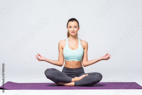 Portrait of young woman meditating in pose of lotus isolated on white background