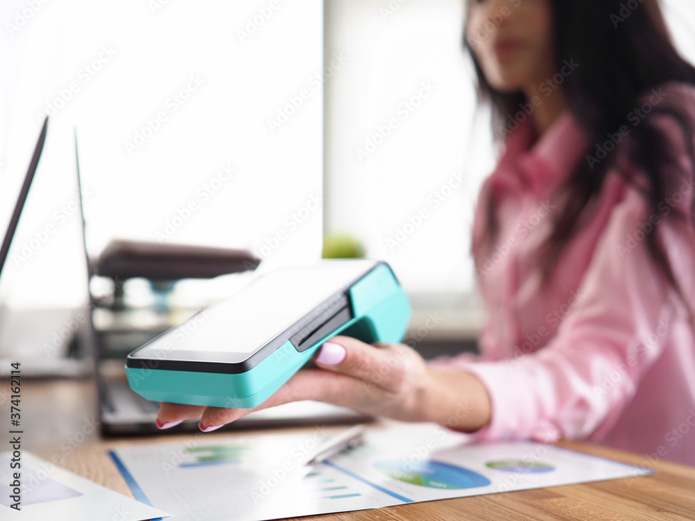 Girl in workplace holds banking mobile device Girl in workplace holds banking mobile device
