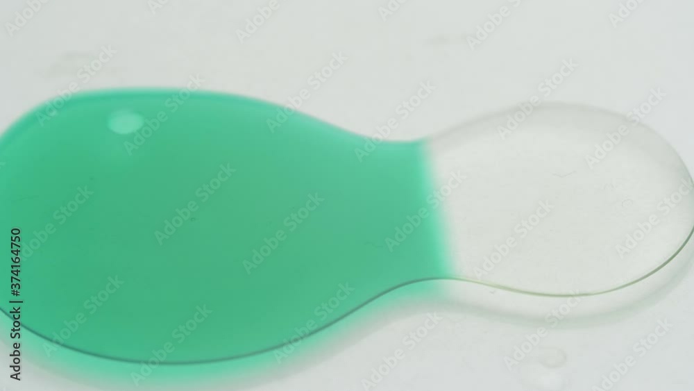 Slow Motion Abstract Shot Of Green And Clear Cosmetic Gel Liquid Merging On The Surface - close up Slow Motion Abstract Shot Of Green And Clear Cosmetic Gel Liquid Merging On The Surface - close up