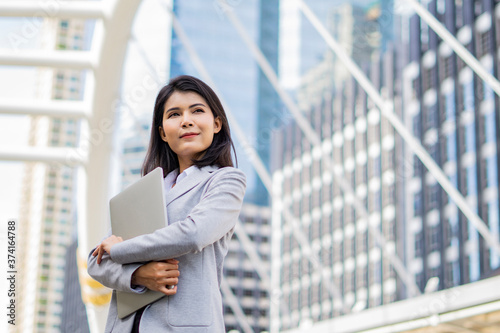 Free Download Business woman hold a laptop while standing on the property business background. - GFXLoad