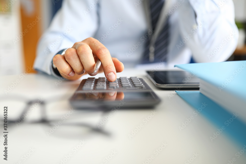 Manager counts on calculator sitting in the office Manager counts on calculator sitting in the office
