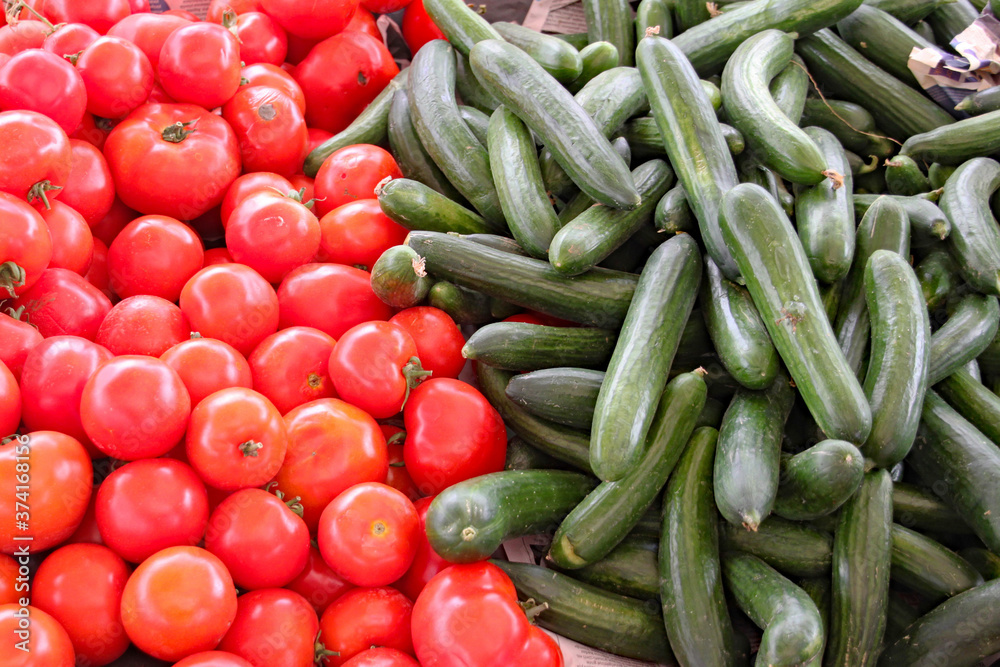 Tomatoes and courgettes on display on a market stall
