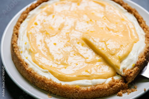 Delicious homemade honey lemon cheese pie and juicy lemon curd on plate.