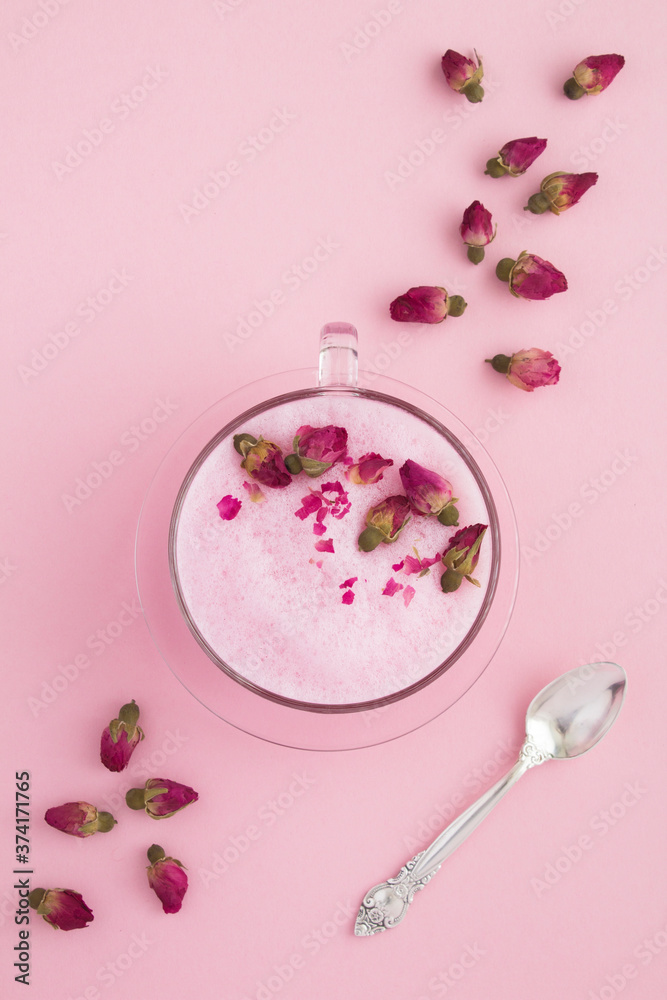 Top view of rose moon milk in glass cup on the pink surface. Location vertical. Top view of rose moon milk in glass cup on the pink surface. Location vertical.