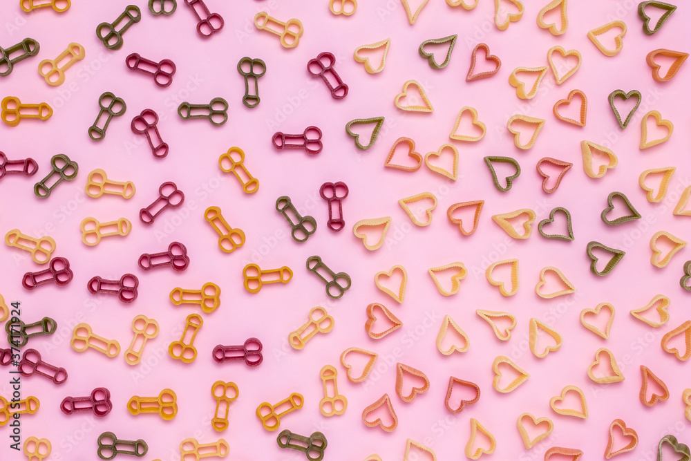 Abstract pattern of pasta in the shape of heart and phallus icon on pink paper background. Symbol of love, sexual health. Romantic concept. The holiday is the day of lovers, valentine's day.