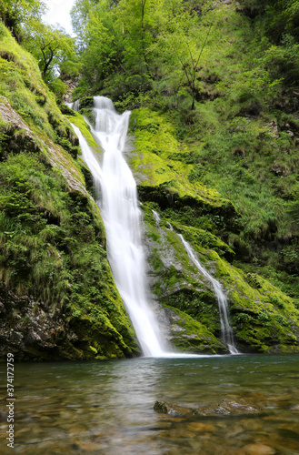 waterfall that flows between the lush vegetation