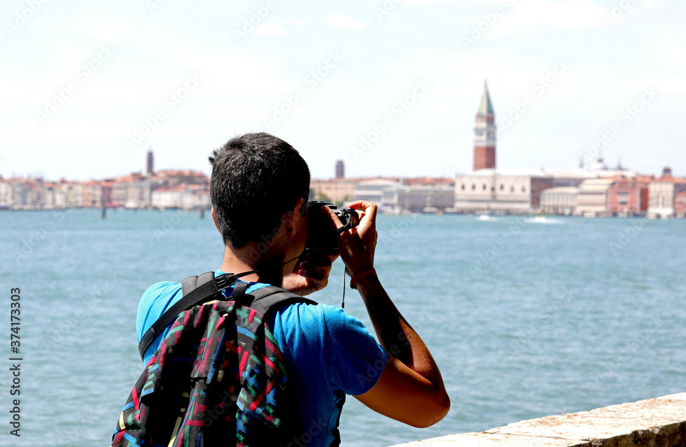 young photographer with backpack on his shoulders while taking a
