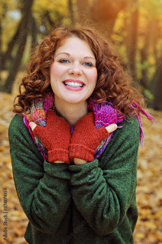 jeune et jolie femme rousse dans un parc arboré en automne avec des feuilles mortes jeune et jolie femme rousse dans un parc arboré en automne avec des feuilles mortes