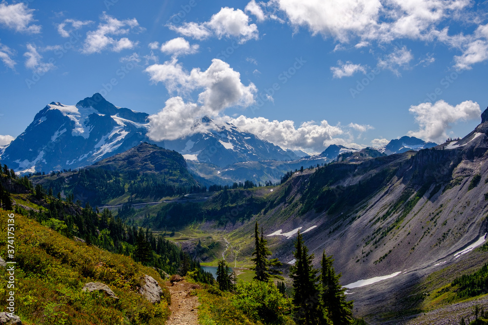 A hiking trail running along a mountainous route with a mountain in the background